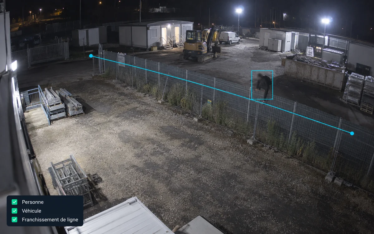 Vue de nuit d’une cour de chantier depuis un mât : une ligne virtuelle le long de la clôture, une silhouette encadrée qui la franchit, et les trois types de détection cochés